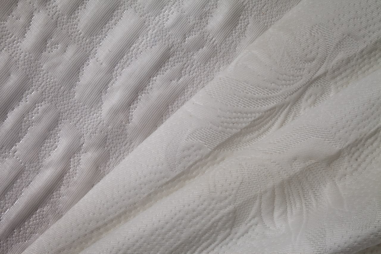 Tela de punto con capitonado floral suave tono crema Goldtex